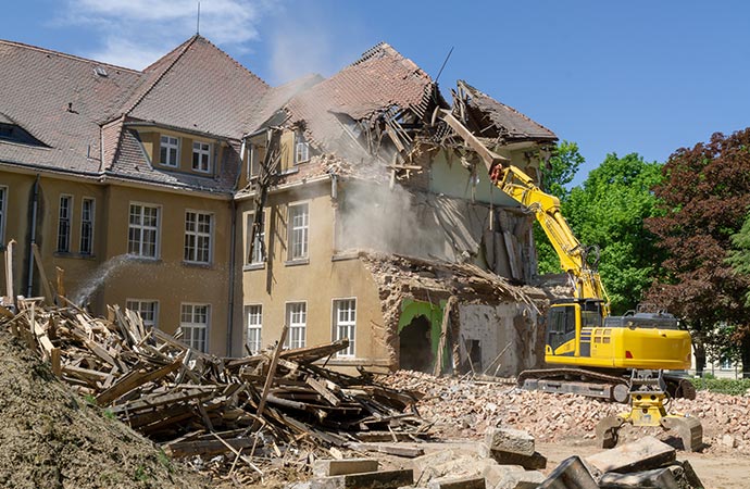 Demolishing by excavator