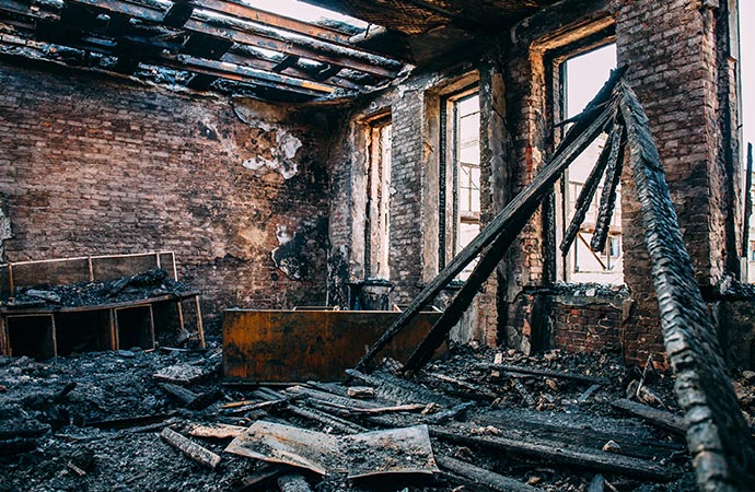 burnt room interior with walls furniture and floor in ash and coal structural fire damage