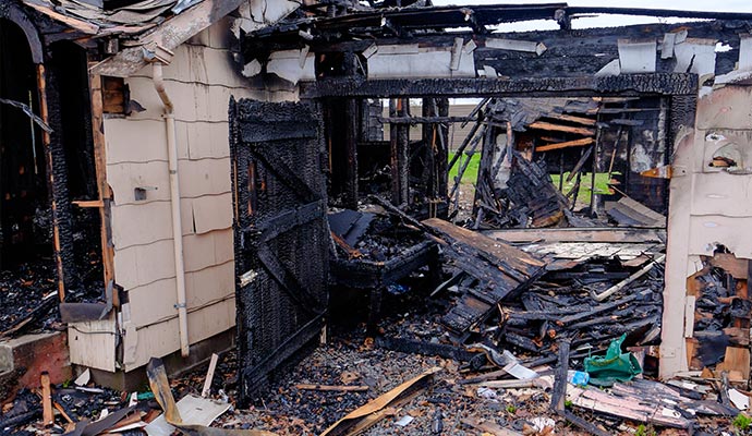 charred ruins of a house destroyed by fire