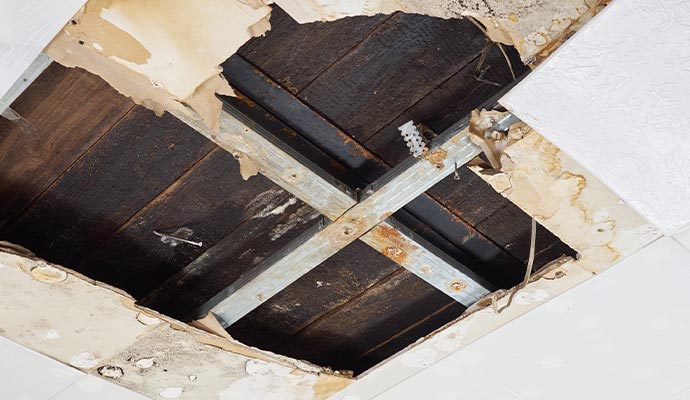 A ceiling with a large hole from water damage