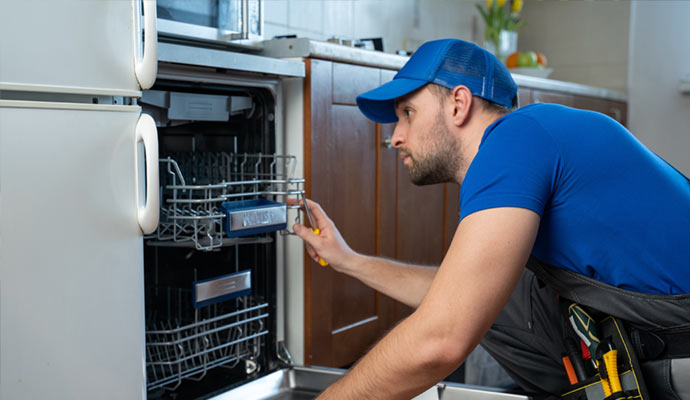 Professional worker repairing dishwasher kitchen