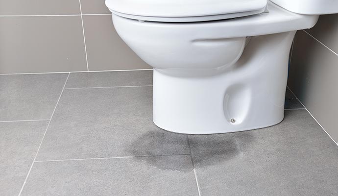 water leaking from base of toilet onto floor