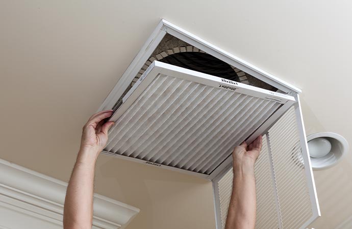 Worker replacing HVAC filter in the ceiling